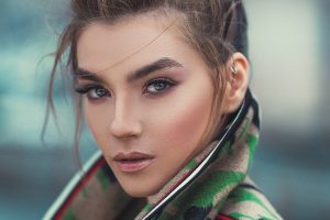 Woman wearing a green jacket has a beautiful make up using the best drugstore toners