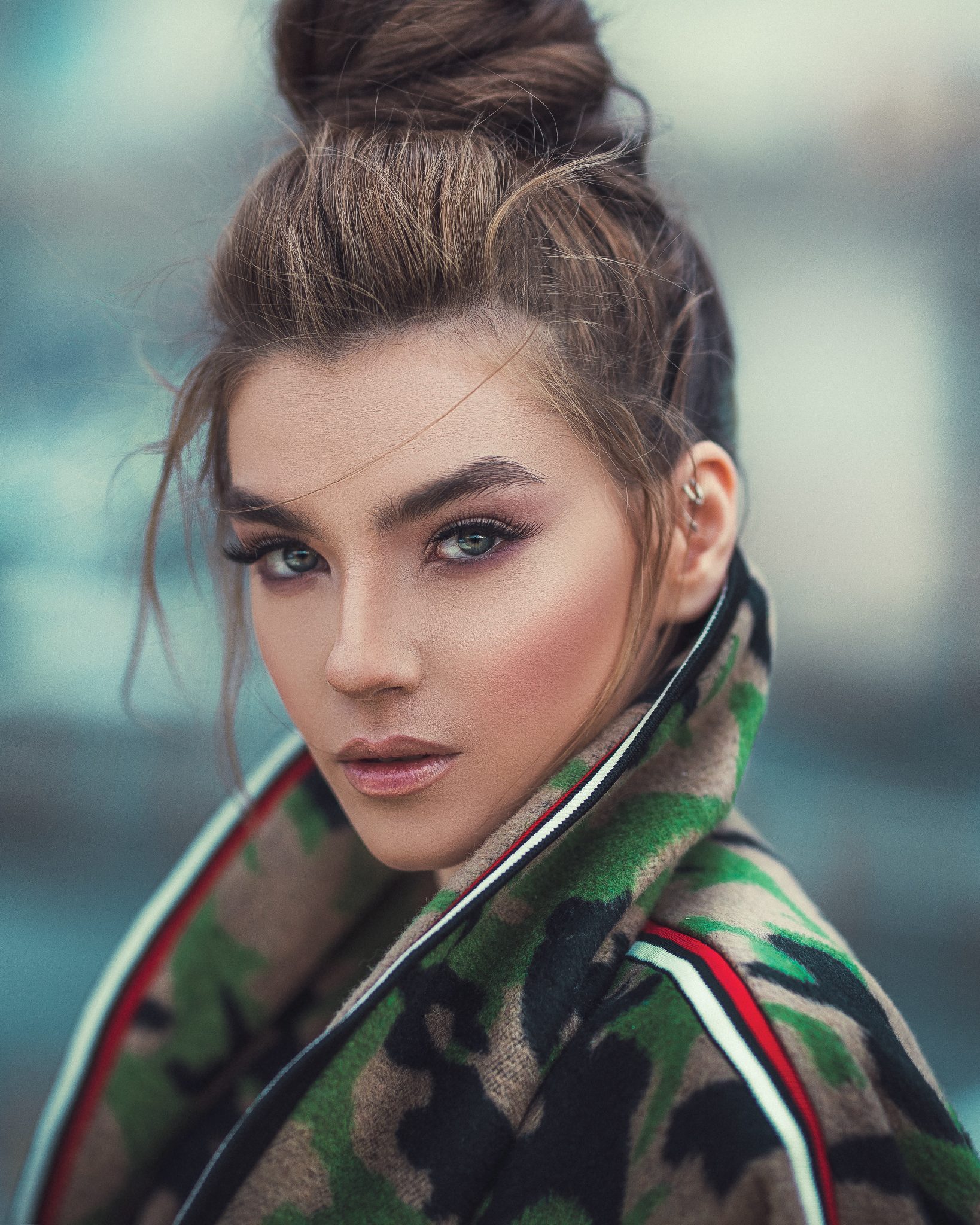 Woman wearing a green jacket has a beautiful make up using the best drugstore toners