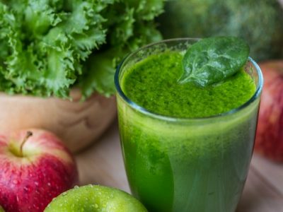 green detox juice in glass and fruits