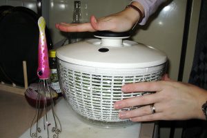 a woman using salad spinner