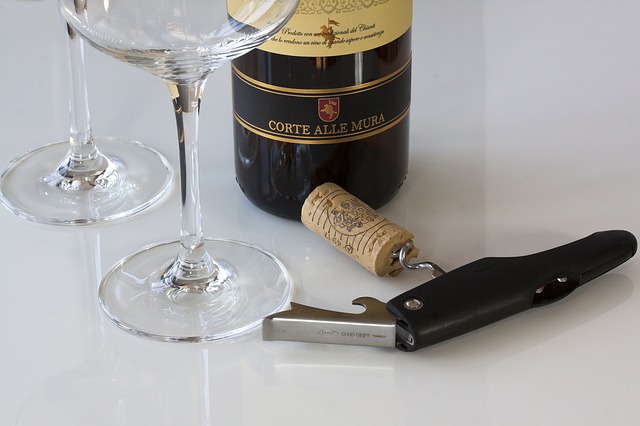 a corkscrew, cork, wine glasses and a wine bottle